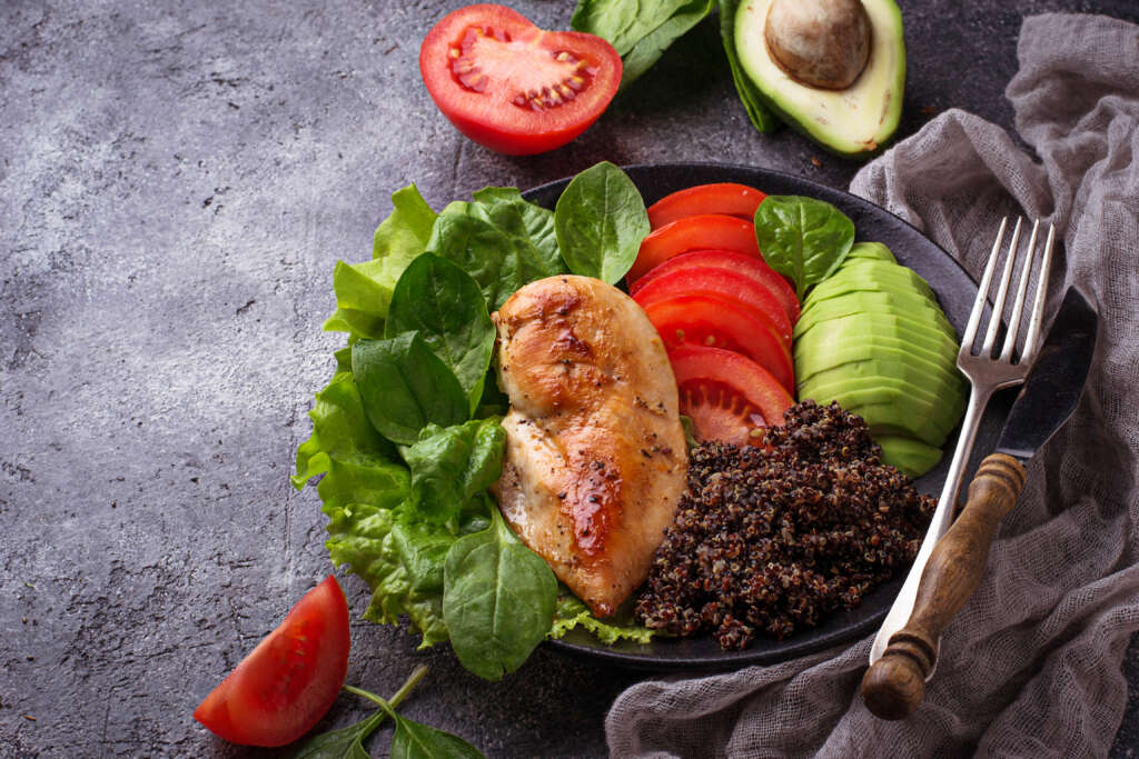 Grilled chicken fillet with black quinoa, salad, tomatoes and avocado. Healthy balanced food